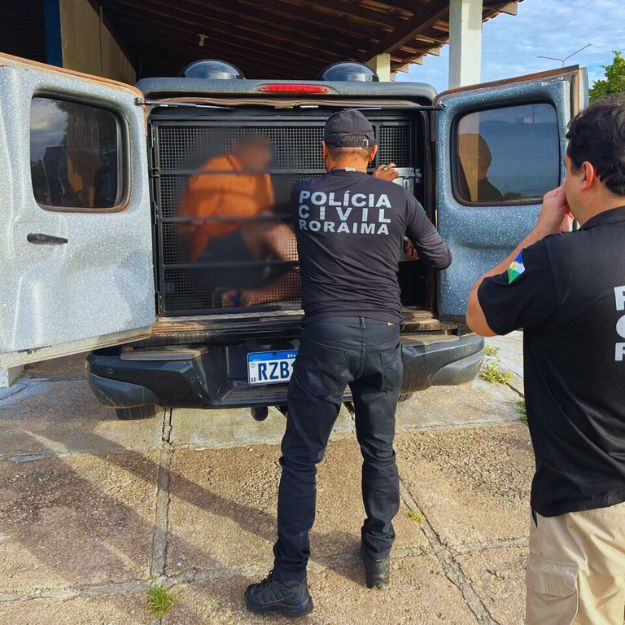 homem preso sendo retirado de dentro do compartimento da viatura por dois policiais civis